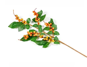 Close-up detail of artificial orange berry branches with green leaves for home decor