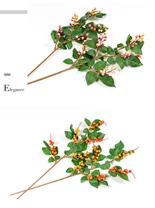 Detailed view of artificial decorative berry branches in red and orange with green leaves