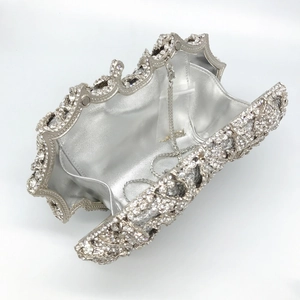 Macro detail of silver clutch bag interior showing metallic lining and detachable chain