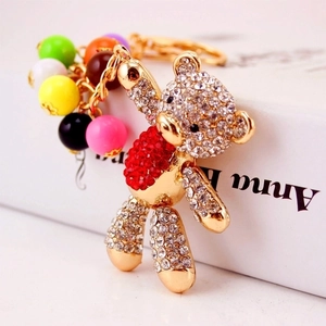 Golden rhinestone cartoon bear keychain with red body and colorful beads pendant