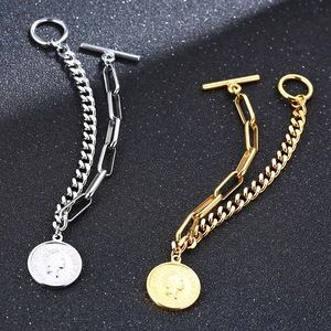Détail de bracelets dorés et argentés avec pendentif pièce de monnaie et fermoir à bascule
