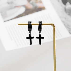 Polished black stainless steel cross hoop earrings displayed on a gold metal stand
