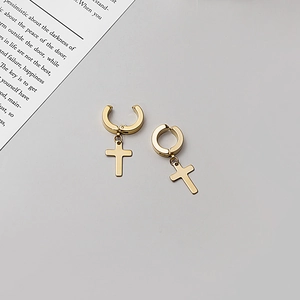 Golden stainless steel cross dangle hoop earrings on a minimalist artistic background