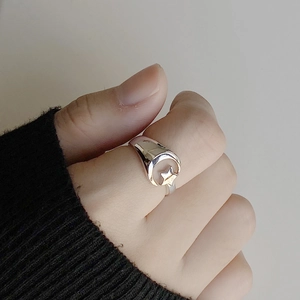 Minimalist 925 silver ring featuring moon and star design worn on a person hand