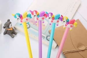 Close-up of four colorful unicorn pens in pink, blue, yellow, and purple on a desk
