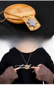 Detail of gold shield pendant with silver star on twisted rope chain for men