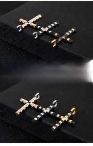 Detailed close-up of three punk style stainless steel cross pendants in gold, silver and black