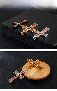 Detail showing multi-layer cross pendants with wood inlay in black, gold, and silver finishes