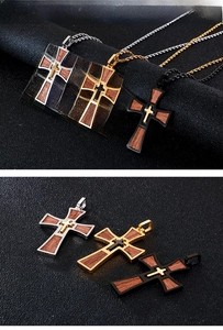 Detailed view of multilayered cross pendants in silver gold and black with wood inlay