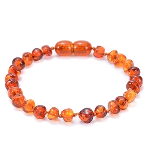 Détail d'un bracelet en ambre de la Baltique pour bébé avec perles et fermoir à vis