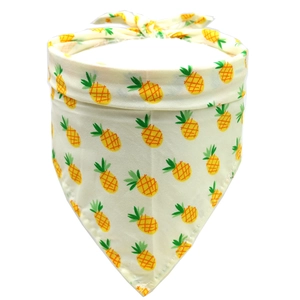 Detail of cotton pet bandana featuring vibrant yellow pineapple patterns on cream fabric