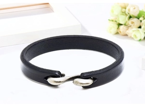 Detail eines schwarzen Lederarmbands mit S-Haken-Metallverschluss auf sauberem Hintergrund