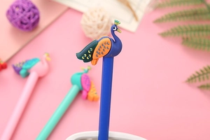 Close-up of a blue cartoon peacock pen with vibrant silicone tail on a soft pink background