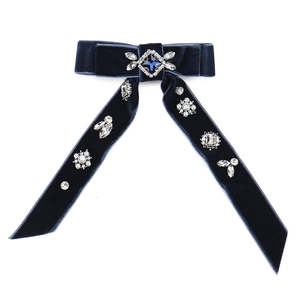 Detail of blue velvet bow hair clip featuring luxury crystals and pearl embellishments