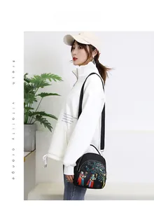 Women's black water-resistant crossbody bag featuring vibrant colorful character print