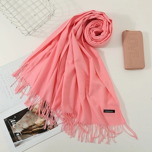 Detail of soft pink cashmere scarf with fringes and authentic material brand label