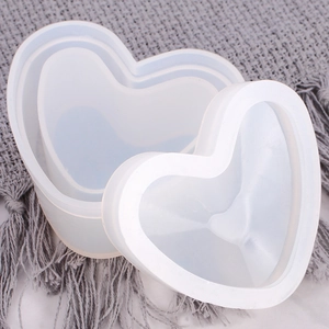 Top view of two-part heart shaped silicone mold for resin storage box on grey texture