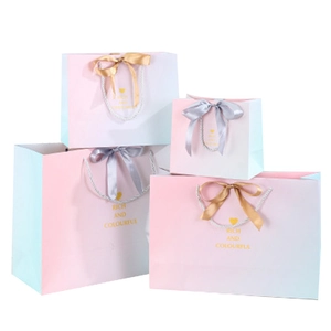 Pink and blue gradient gift bags in four sizes with ribbon bows and rope handles