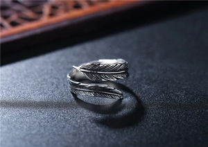 Macro shot of silver feather open ring with vintage oxidized finish on steel surface