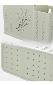 Detail of green wall-mounted utensil holder with grain patterns and drainage holes
