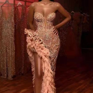 Champagne sequin strapless evening gown featuring high slit and pink feather fringe trim