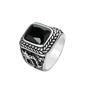 Macro shot of men's vintage steel ring with large faceted black gem and relief patterns