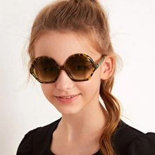 Front view of a child wearing vintage tortoiseshell sunglasses with brown gradient lenses