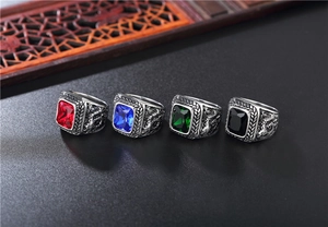 Macro detail of men's dragon engraved rings with large rectangular colored gemstones