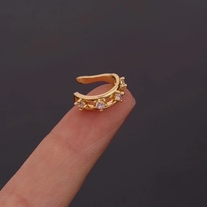 Gold U-shaped ear cuff featuring five sparkling zircon stones shown on ear cartilage