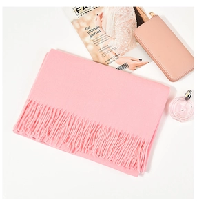 Close-up of pink cashmere scarf texture with tassel details and fashion accessories