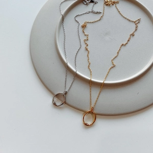 Detail of irregular round pendants in gold and silver finish on a minimalist tray
