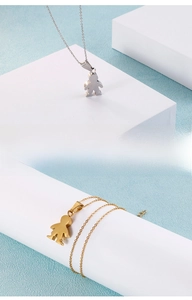 Polished silver and gold necklaces featuring flat boy and girl pendants on cross chains