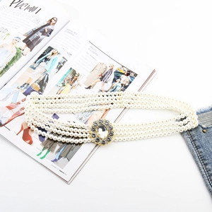 Detailed view of triple-row white pearl elastic belt with a sparkling rhinestone gold buckle