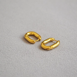 Détail des boucles d'oreilles créoles en U plaquées or avec une finition polie