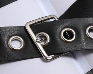 Macro shot of the black leather belt featuring square silver buckle and metal eyelets