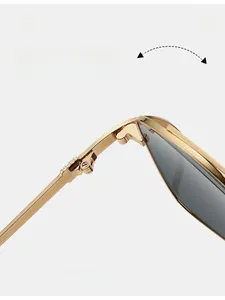 Detail of durable gold metal hinge on irregular cat-eye sunglasses with dark lenses