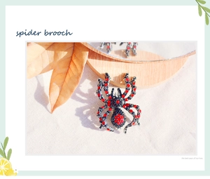 Detailed macro shot of a black spider brooch with red rhinestones on a rustic background