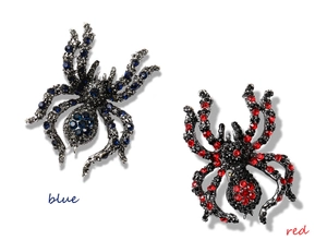 Detailed view of rhinestone-encrusted spider brooches in blue and red crystal accents