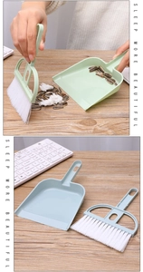 Close-up of mini desktop broom and dustpan set cleaning sunflower seeds on wood