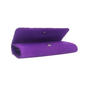Détail d'une pochette de soirée en satin violet avec dentelle et fermoir magnétique