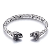 Detail of silver twisted cable cuff bracelet with engraved lion heads on a white background