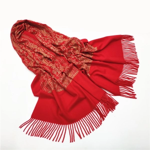Detailed view of red cashmere-like scarf with gold embroidery and decorative tassels