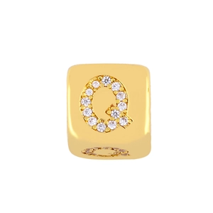 Macro view of gold-plated cube charm with sparkling zircon letter Q for DIY jewelry