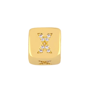Detail shot of a golden letter X pendant with micro-paved cubic zirconia stones