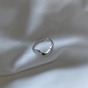 Detailed macro shot of 925 silver Mobius ring with wavy texture on white fabric