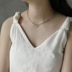 Detail of 925 sterling silver chain necklace with OT clasp worn on v-neck dress