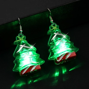 Festive glowing green LED Christmas tree earrings with hooks on dark background