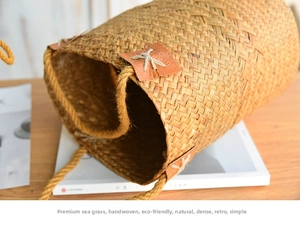 Close-up of seagrass woven basket featuring rustic rope handle and brown leather patch