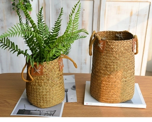 Close-up of natural seagrass woven baskets with leather accents on a wooden table