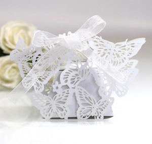 Close-up of laser-cut butterfly wedding favor box with elegant white organza ribbon